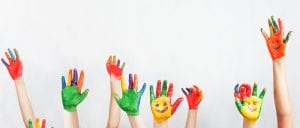 children raising painted hands for inquiry based learning