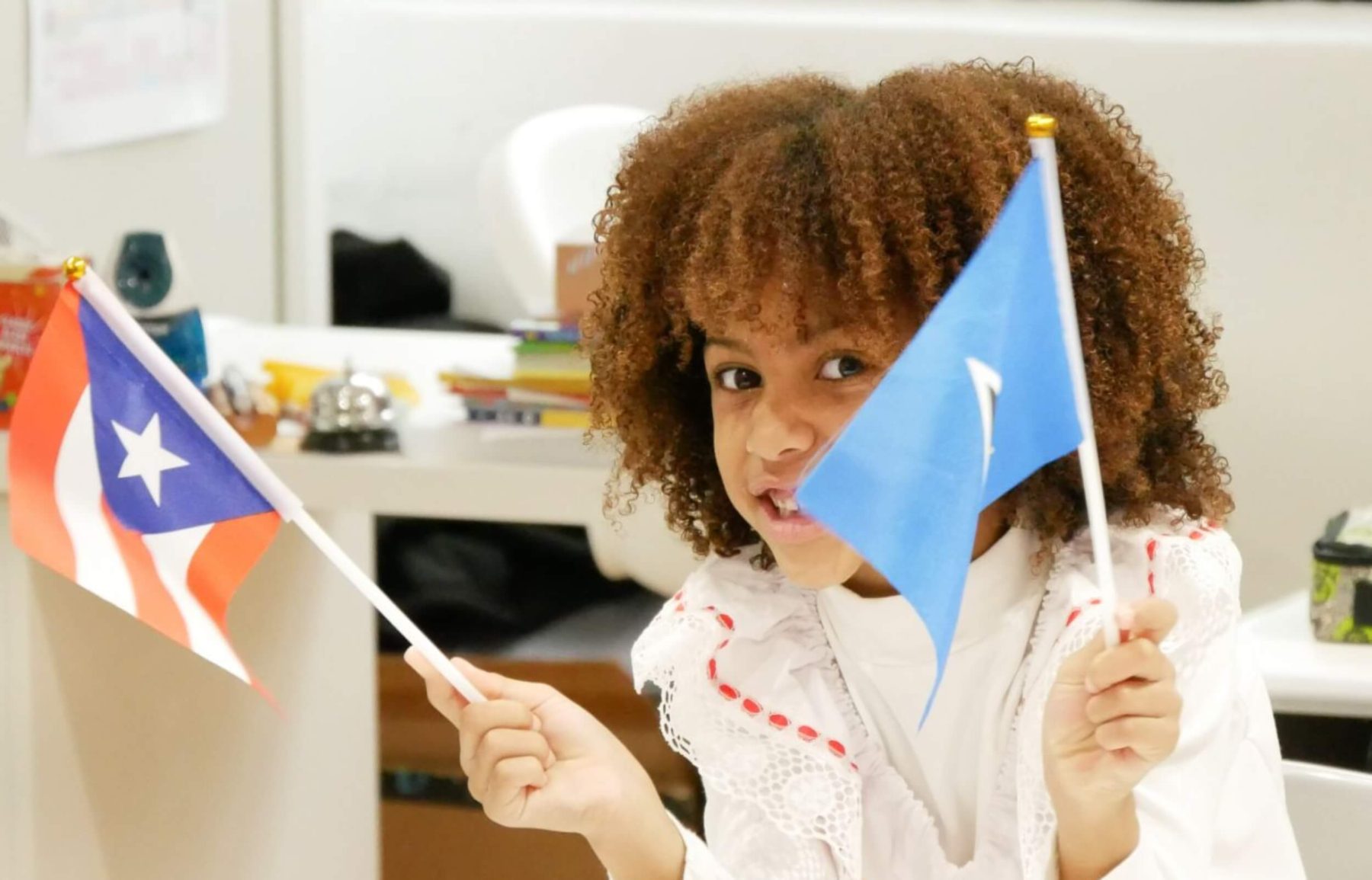 A student in the international baccalaureate program waving two flags