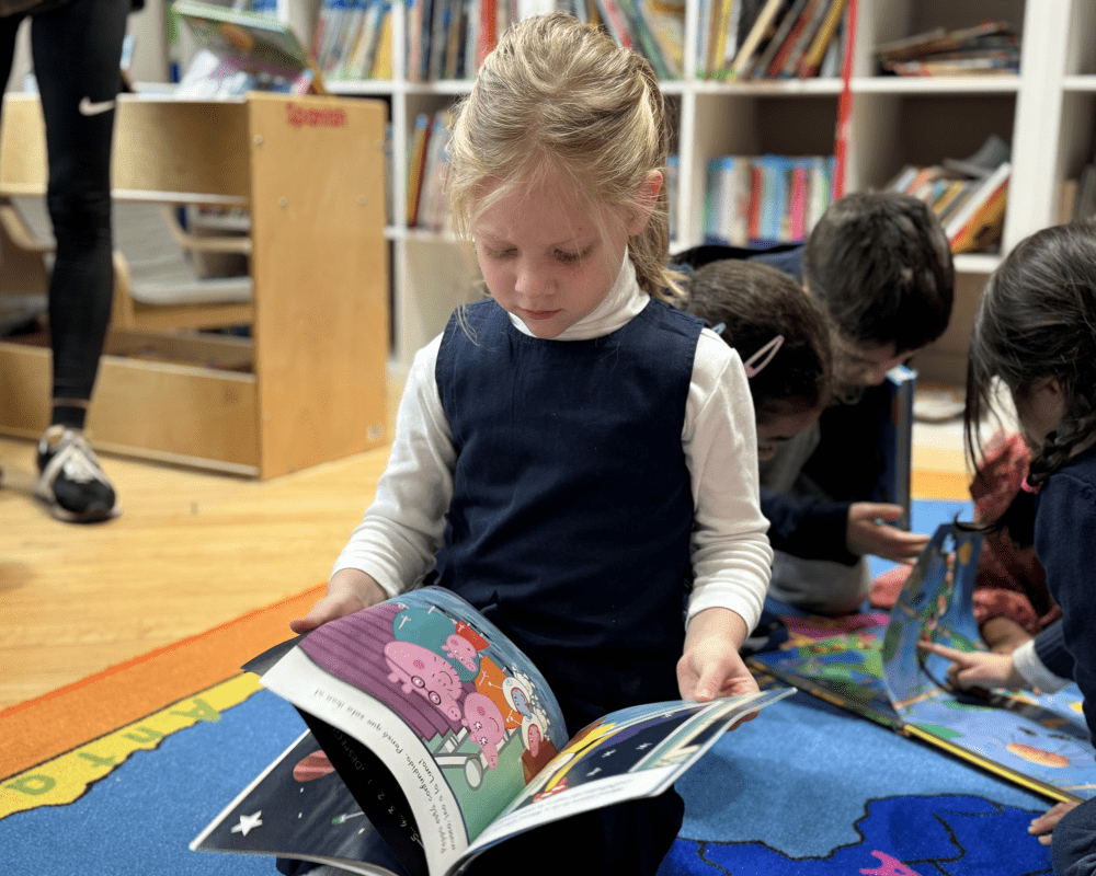 Student/ Girl reading Peppa Pig in the school library