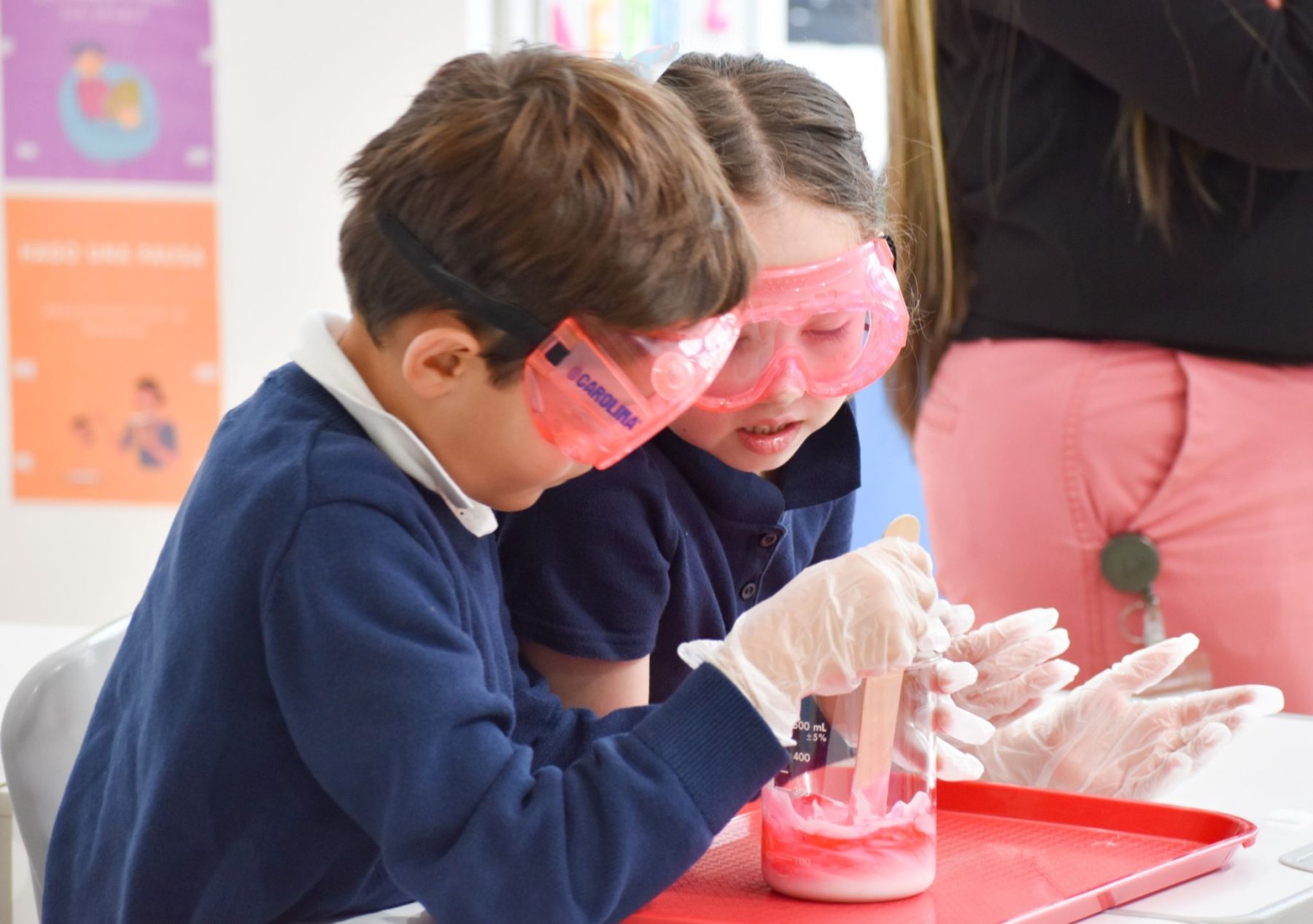 A pair of international school students doing a science experiment at a table 