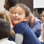 A girl smiles happily on the first day back to school