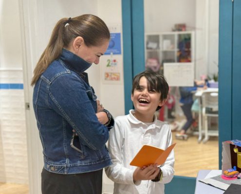 A parent engages in his son's sharing of his learning in IB PYP.