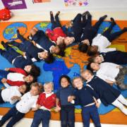 A diverse group of students from various races, ethnicities, and cultural backgrounds collaborating in a classroom at Tessa International School.