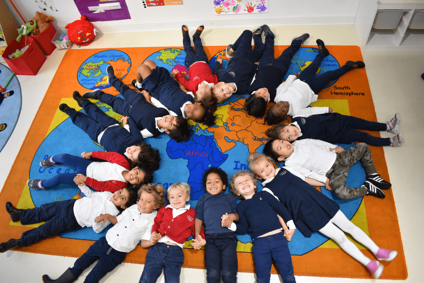 A diverse group of students from various races, ethnicities, and cultural backgrounds collaborating in a classroom at Tessa International School.