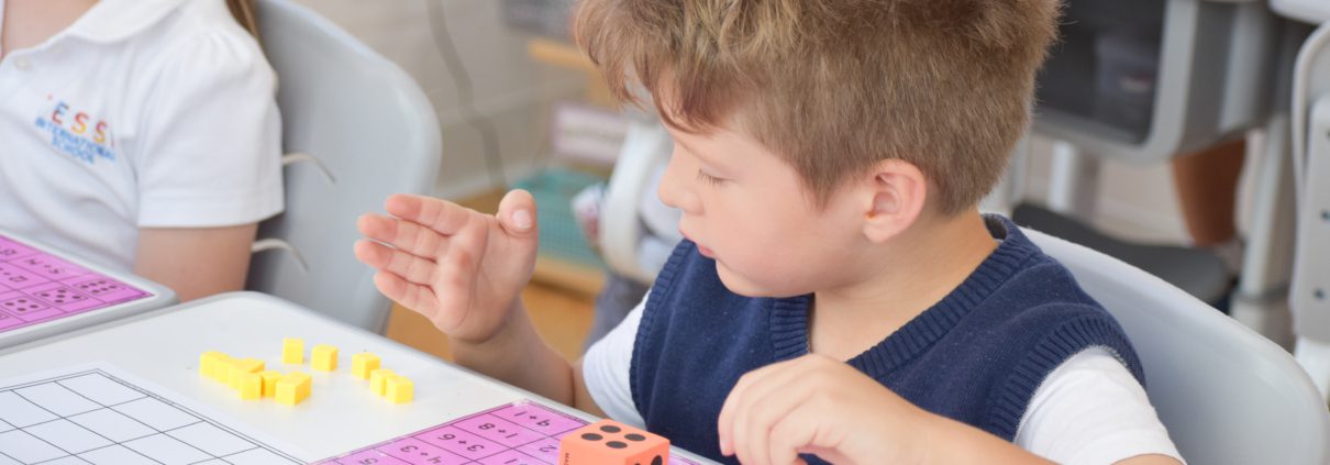 A student learns additions and subtractions with counting cubes.