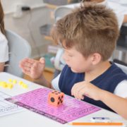 A student learns additions and subtractions with counting cubes.