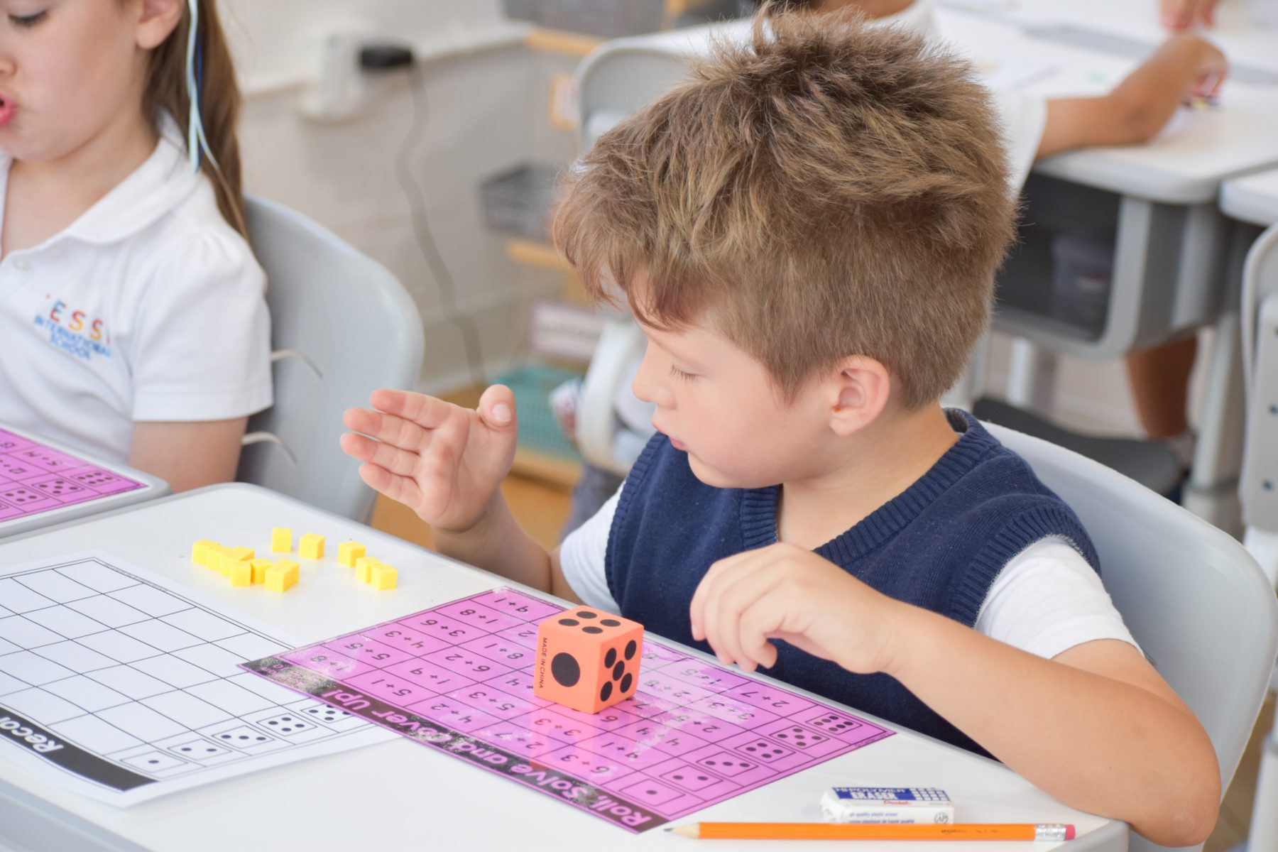 A student learns additions and subtractions with counting cubes. 