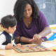 A preschooler concentrates on his Math Assessment, monitored by his teacher at Tessa International School.