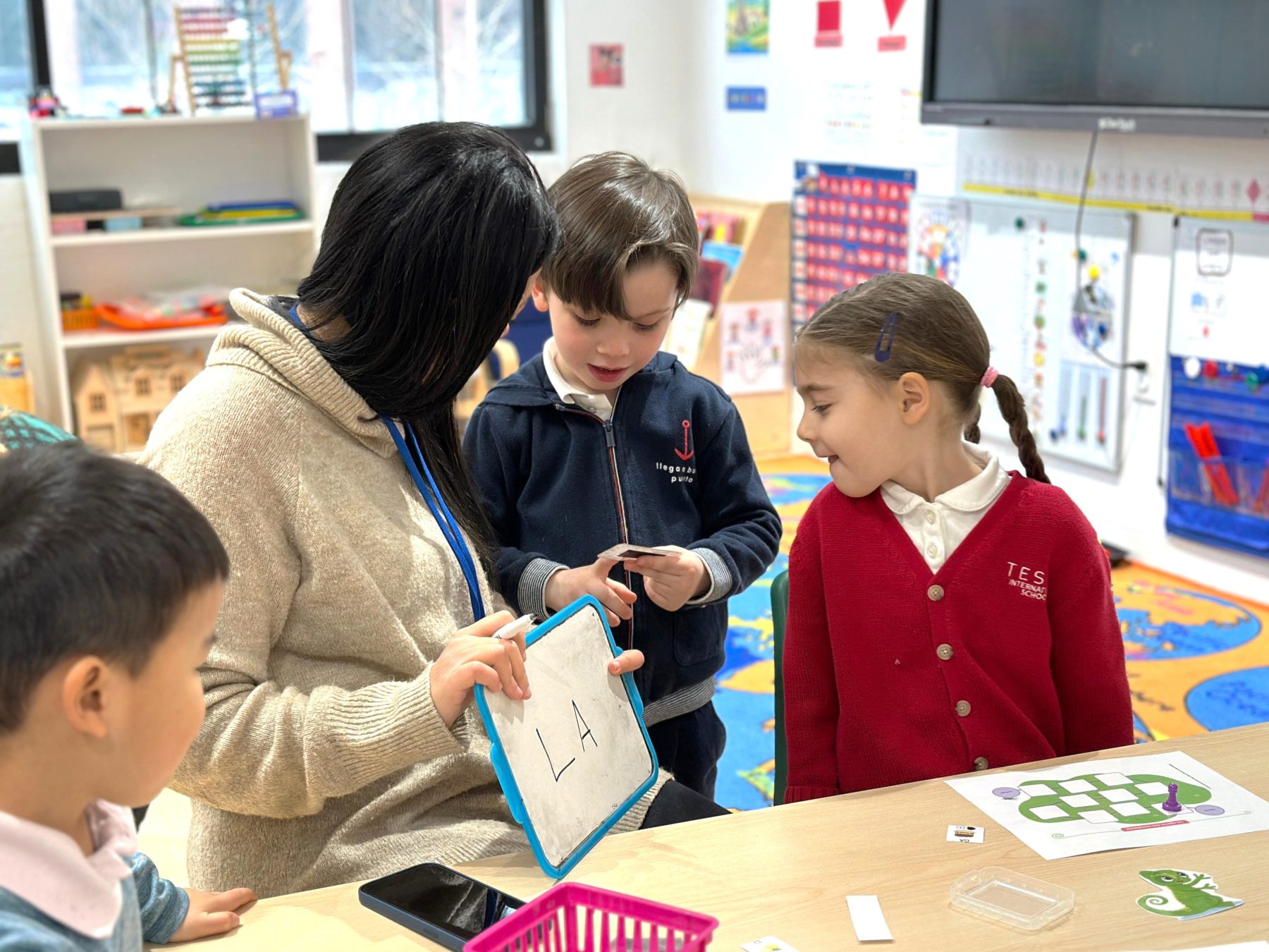 Three French Track Kindergarteners at Tessa International School are developing their bilingual skills with the teacher. 