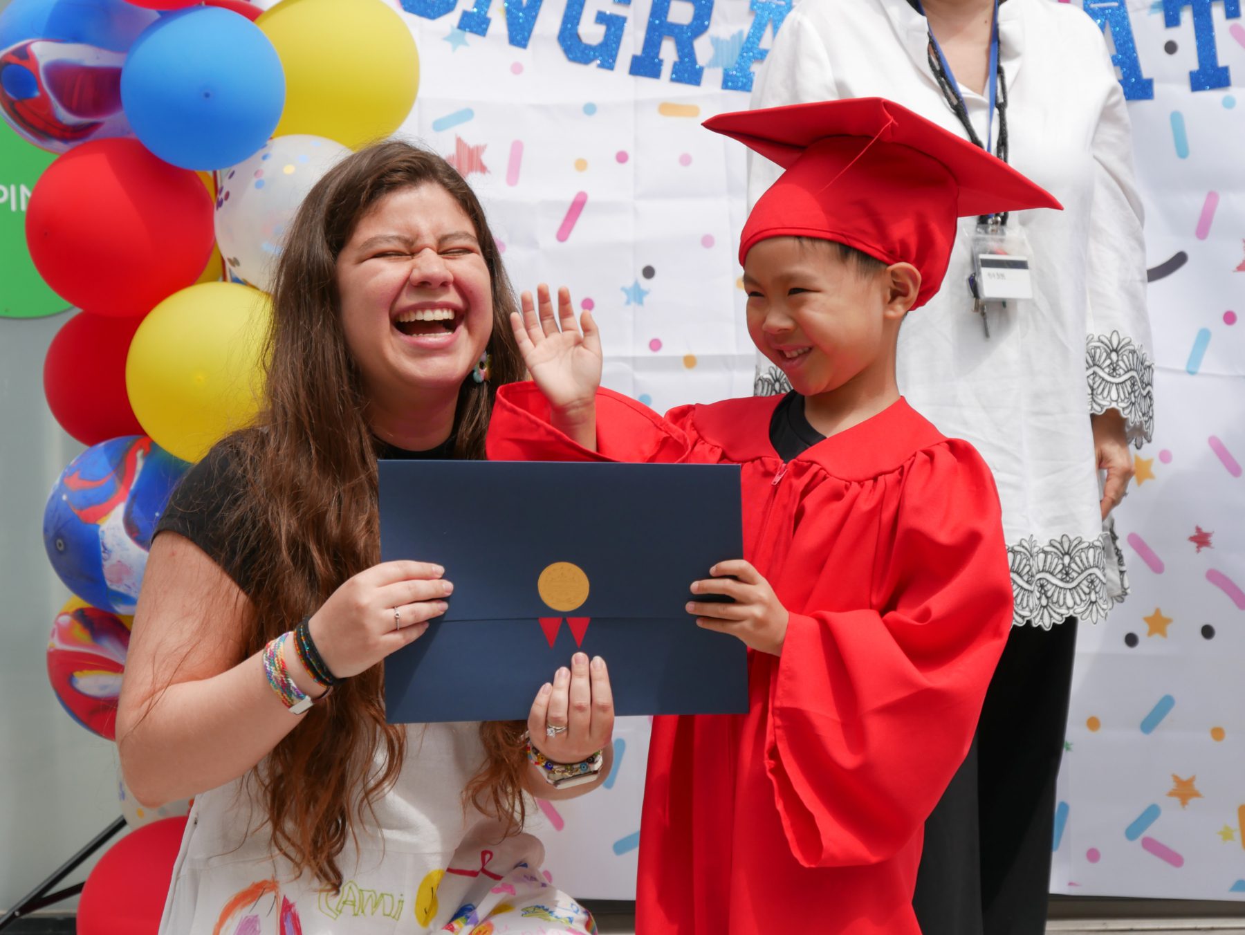 A Tessa kindergartener at his graduation ceremony with the proud teacher