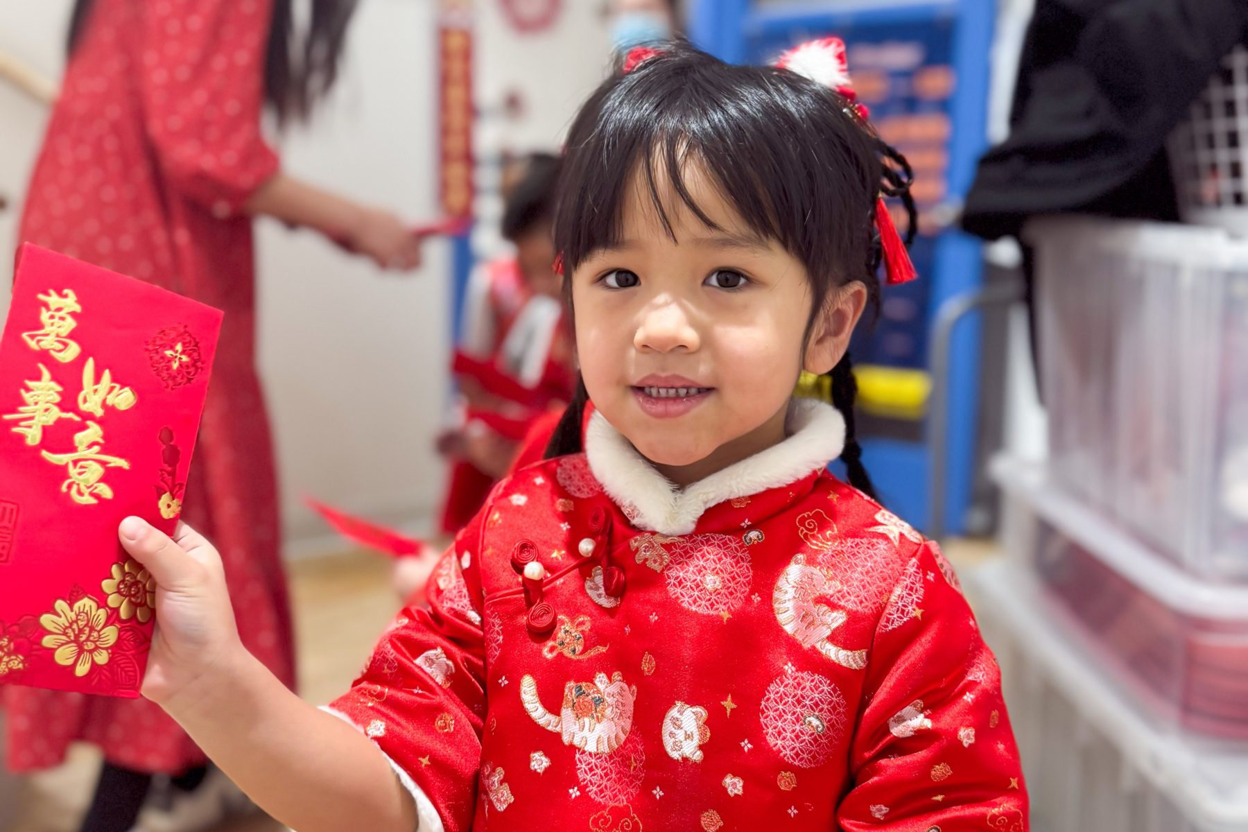 A Mandarin students happily shows her red envelope for the Lunar New Year. 