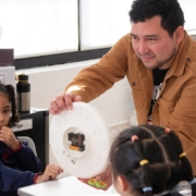 The STEM teacher shows the inner structure of a clock to Grade 1 students at Tessa International School.
