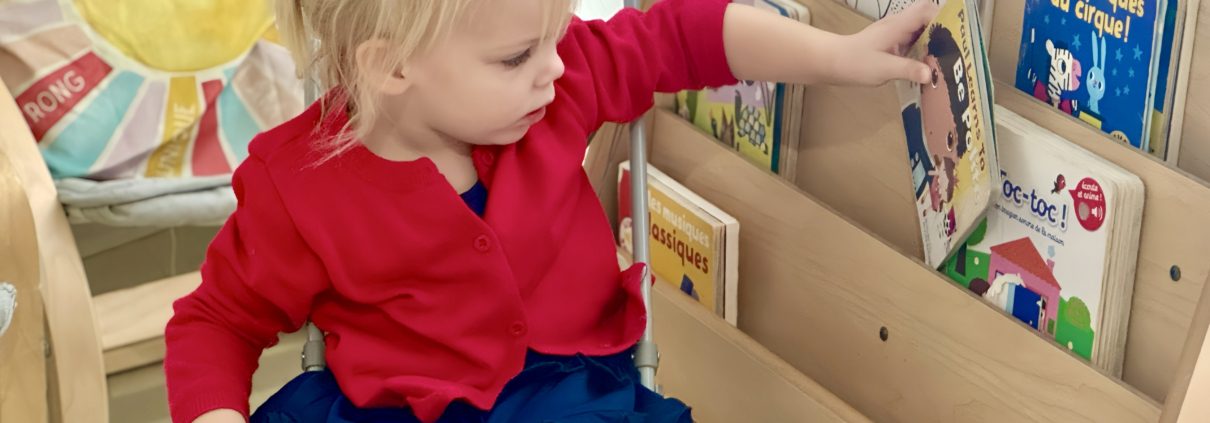 A girl in Tessa International School's Nursery French program picking the book to read