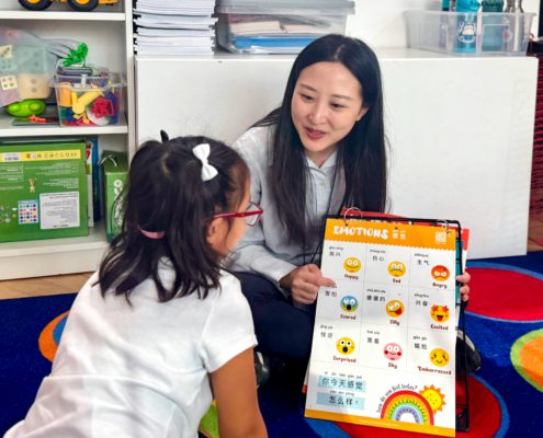 A preschool teacher is teaching how to express different emotions in Mandarin.