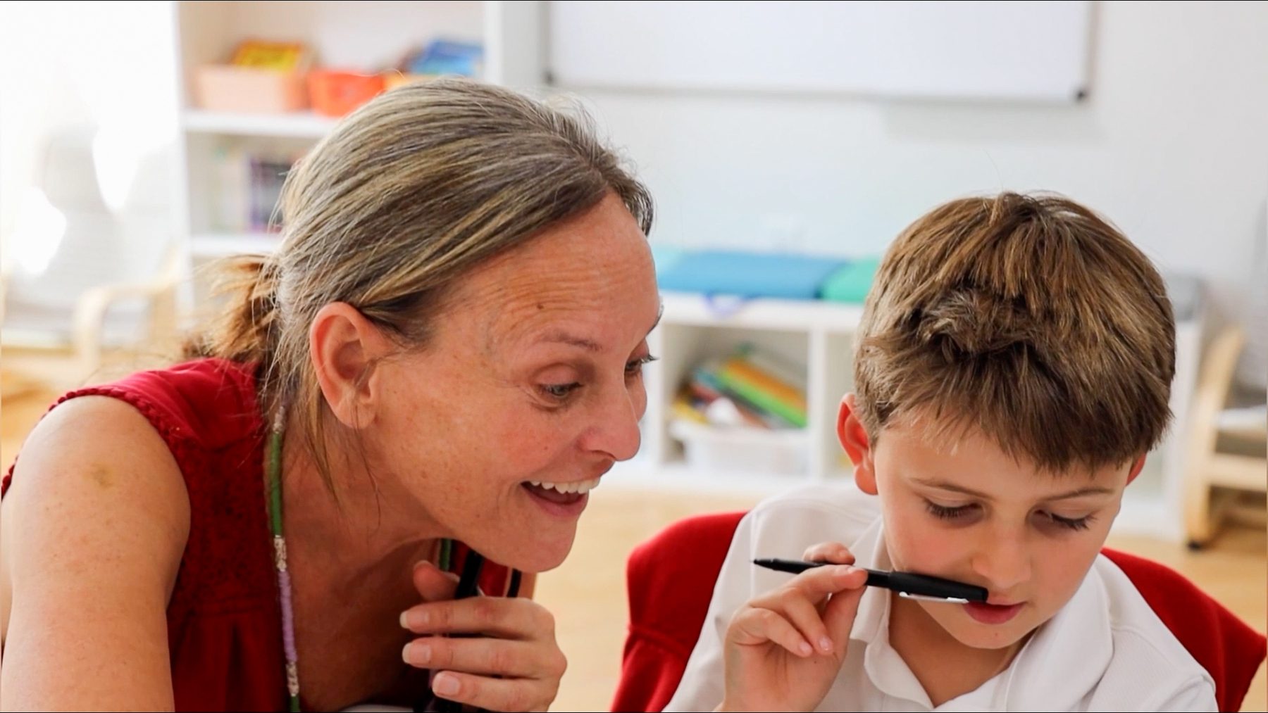 A Primary student writing with his English Teacher at Tessa International School