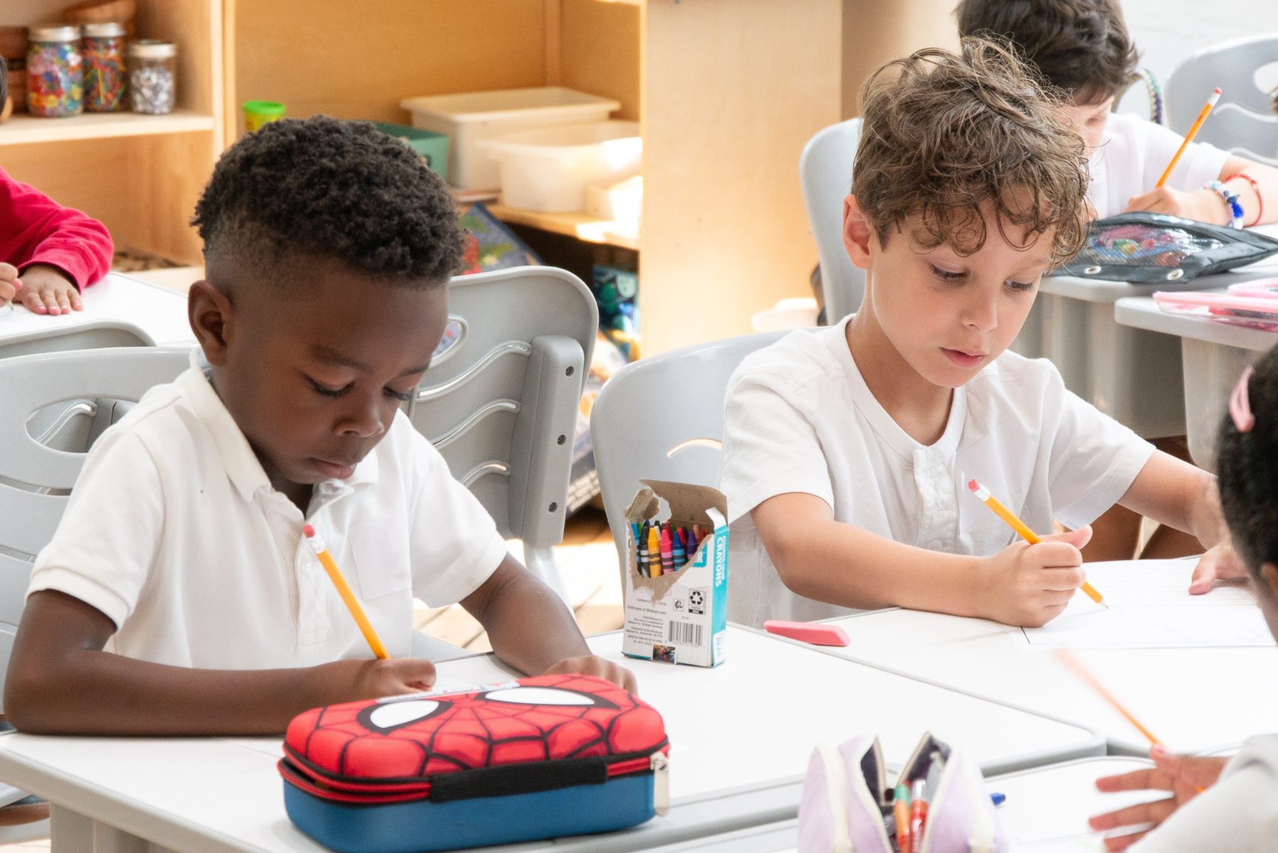 Two first graders focus on their tasks at Tessa International School. 